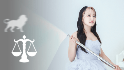 윤하가 사자와 천칭 저울을 등지고 깃발을 들고 걸어가는 장면